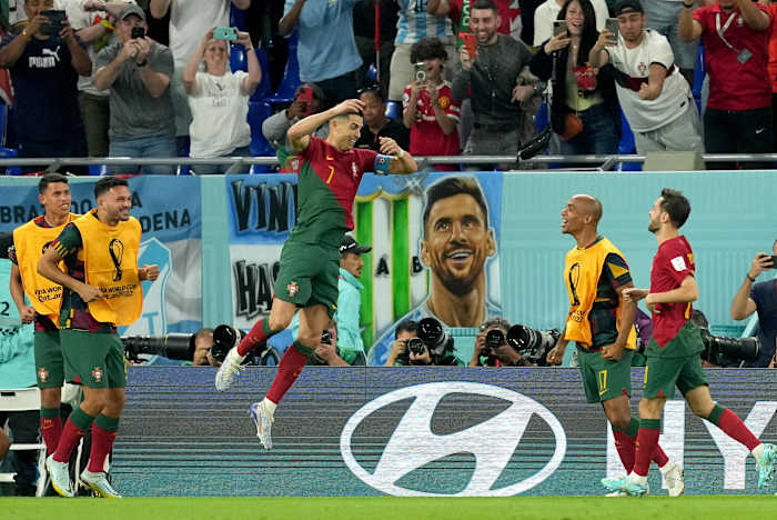 Cristiano Ronaldo pictured jumping in the air to celebrate the goal that made him the first player ever to score at five different FIFA World Cups